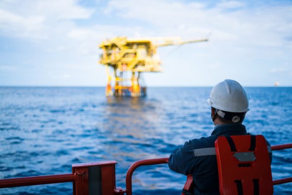 Offshore worker looking at oil rig